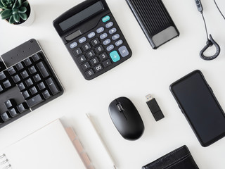 top view of office desk table with  calculator, notebook, plastic plant, smartphone and keyboard on white background, graphic designer, Creative Designer concept.