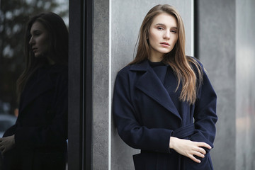 Beautiful girl in a coat in business downtown
