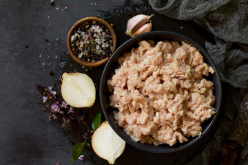 Minced meat and ingredients for cooking minced meat in a bowl on a slate. Top view.