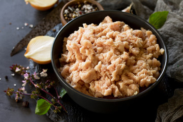 Minced meat and ingredients for cooking minced meat in a bowl on a slate.