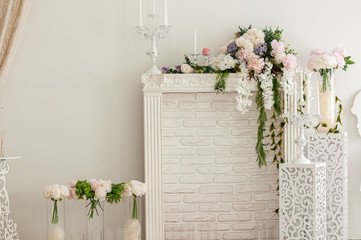 White fireplace with candles and bouquet of flowers