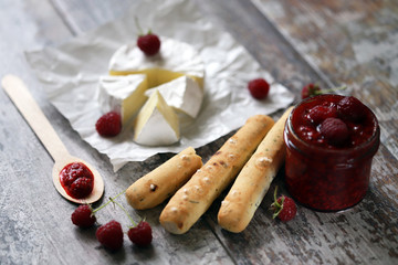 Selective focus. Macro. Camembert cheese with raspberry sauce.