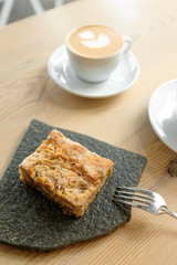 cup of cappuccino with a piece of cake.