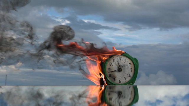 Burning old  clock in space on sky background, slow motion