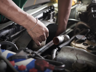 Hands of car mechanic holding the fan of Radiator in garage. Car repair