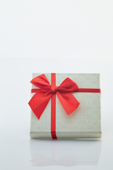 White gift box with red ribbon bow on white