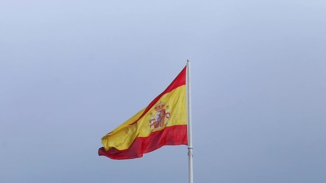 Spain national flag on a pole slow motion windy day blue sky