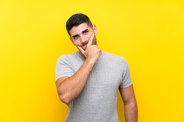 Young handsome man over isolated yellow background thinking an idea