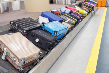 Multicolored suitcases and bags on luggage conveyor belt
