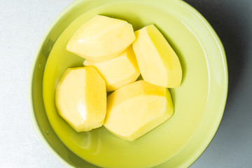 Peeled new potatoes in deep dish with water to remove nitrites.