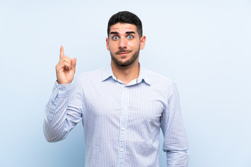 Fototapeta premium Caucasian handsome man over isolated blue background pointing with the index finger a great idea