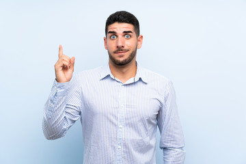 Caucasian handsome man over isolated blue background pointing with the index finger a great idea