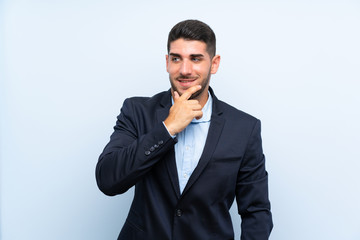 Handsome man over isolated blue background looking to the side