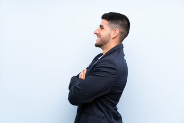 Handsome man over isolated blue background in lateral position