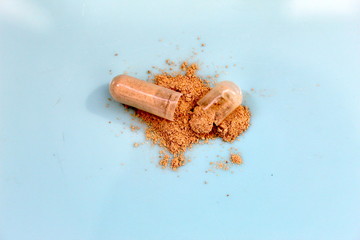 broken capsule with medicine blue backgraund