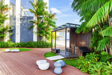 Beautiful rooftop garden. Modern wooden arbor among green trees