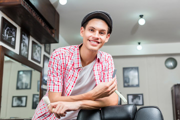Smiling professional hairdresser posing in salon