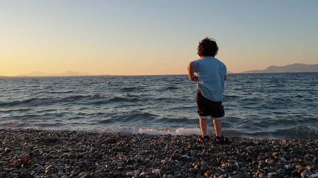 Boy picking stones on the beach of Kos Island in Greece