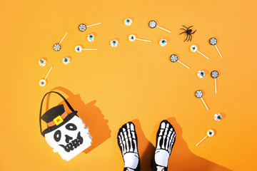 Happy halloween with candies and bucket on orange background
