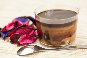 Bowl with delicious chocolate cream, spoon and nuts on wooden table