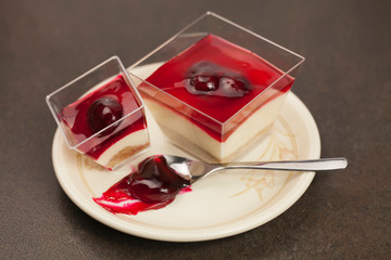 dessert with creamy cream, cherry and chocolate on a concrete background.
