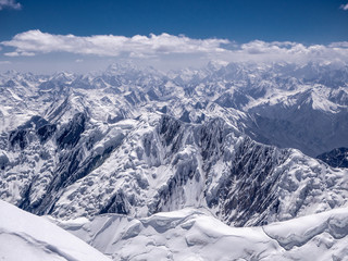 Fototapeta na wymiar Amazing view from the Lenin peak's summit. Snow covered peaks in the Pamir.