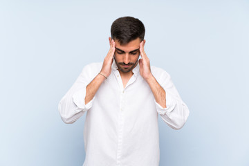 Handsome man with beard over isolated blue background with headache
