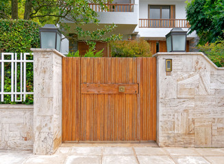 contemporary house exterior with solid wood door and stone fence