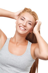 Fototapeta premium Young blonde girl in a gray shirt looks at the camera and smiles