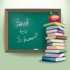 A stack of books and apple near the school board