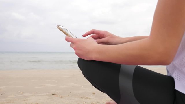 Woman slide her fingure on smartphone at the beach