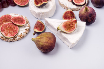 Brie Cheese and Ripe Figs on Blue Background Selective Focus Horizontal