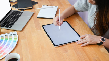 Fototapeta na wymiar Creative woman using tablet computer on creativity office desk.