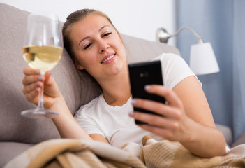 Young female with modern mobile and wine