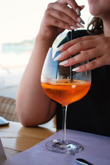 Girl drinks an aperol syringe through a straw