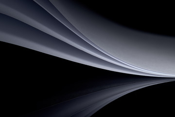 curved white sheets of paper against a dark background