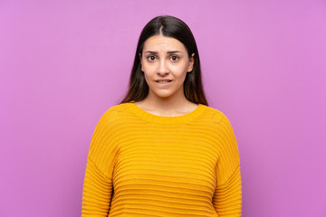 Fototapeta premium Young woman over isolated purple background having doubts and with confuse face expression