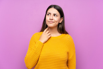Fototapeta premium Young woman over isolated purple background thinking an idea
