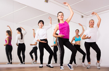 Cheerful different ages women learning swing steps at dance class