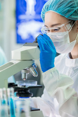 asian scientist use microscope