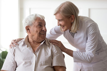 Senior man clinic patient interacting with nurse in white coat
