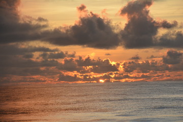Sunrise over the sea on a partly cloudy dawn