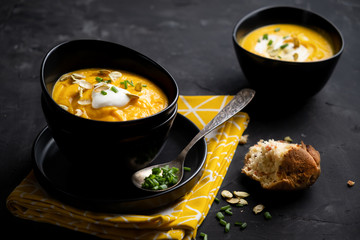 Pumpkin soup with sour cream, herbs and pumpkin seeds.