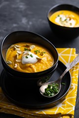 Pumpkin soup with sour cream, herbs and pumpkin seeds.