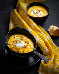 Pumpkin soup with sour cream, herbs and pumpkin seeds.