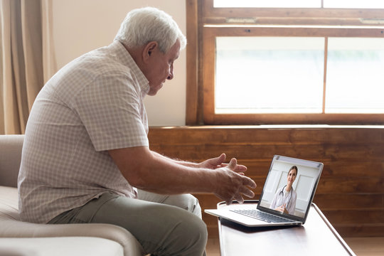 Senior man video chats with doctor online in telehealth visit
