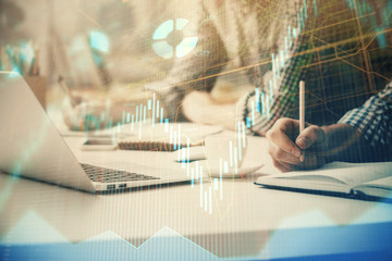 Multi exposure of forex chart with man working on computer on background. Concept of market...