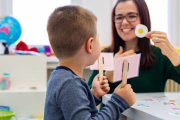 Children speech therapy concept. Preschooler practicing correct pronunciation with a female speech...