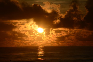 Fototapeta na wymiar Sunrise over the sea on a partly cloudy dawn