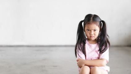 Asian child cute touchy or kid girl sitting face frown and angry aggressive with sad or have...